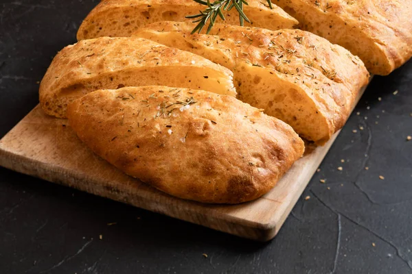 Sliced bread Ciabatta and rosemary on wooden board — Stock Photo, Image