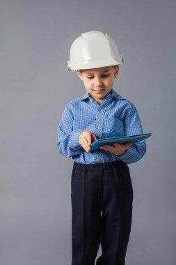Mühendis kostümü giymiş tabletli küçük çocuk.