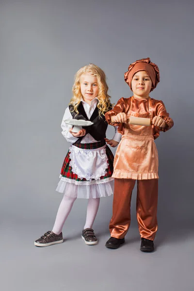 Los niños posan con los trajes de un camarero y un cocinero — Foto de Stock