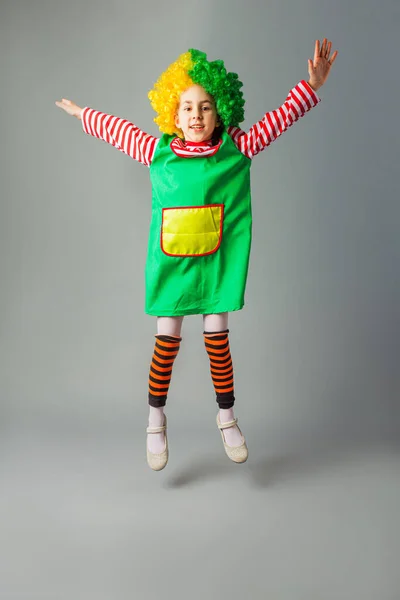 A menina salta em um uniforme de palhaço — Fotografia de Stock