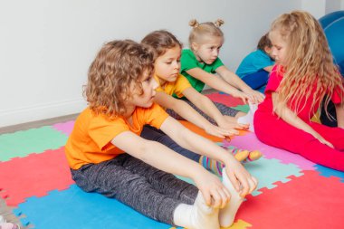 Meraklı anaokulu çocuğu grup jimnastiğinin keyfini çıkarıyor.