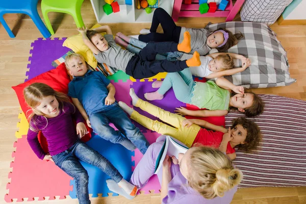 Actieve kinderen op zachte kussens en matten op de kleuterschool — Stockfoto