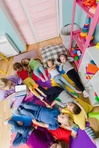 Actieve kinderen op zachte kussens en matten op de kleuterschool — Stockfoto