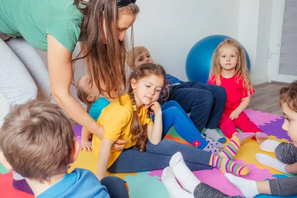 Nauczyciel pocieszający zdenerwowaną dziewczynę po niepowodzeniu podczas ćwiczeń fizycznych — Zdjęcie stockowe