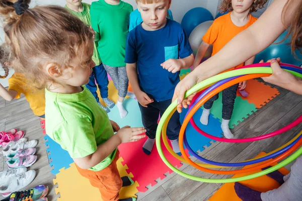 Lehrer gibt ungeduldigen Kindern Hula-Hoop-Reifen — Stockfoto