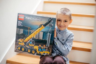 UZHOROD, UKRAINE - 17 Mart 2021: Lego Teknolojisi 'nin kutusunu tutan mutlu çocuk