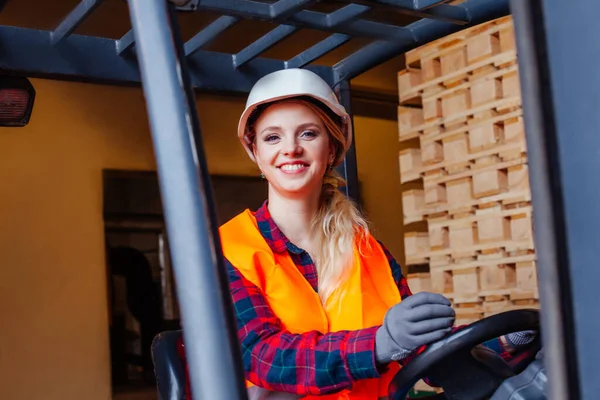 Mulher sorridente dirigindo empilhadeira no armazém — Fotografia de Stock