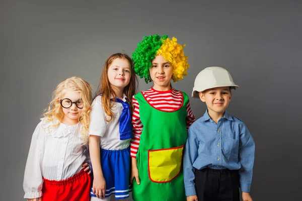 Los niños alegres en diferentes profesiones trajes — Foto de Stock