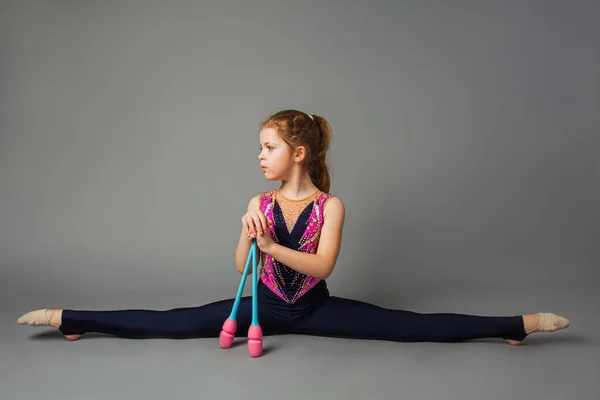 Het kleine meisje turner poseert met instrumenten — Stockfoto