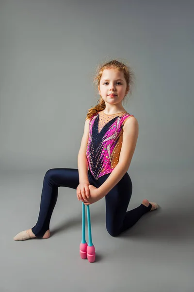 La petite fille gymnaste pose avec des instruments — Photo