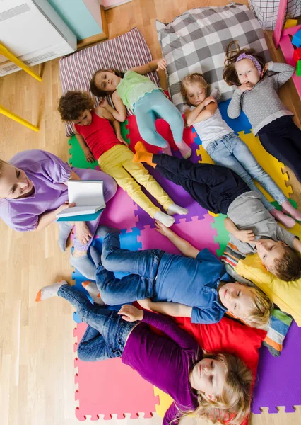 Actieve kinderen op zachte kussens en matten op de kleuterschool — Stockfoto