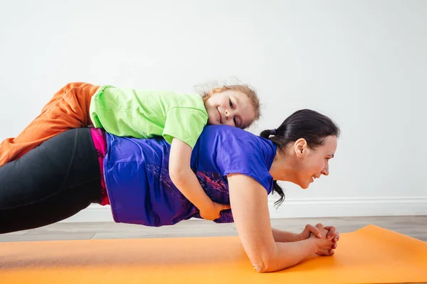 Actieve jongen leggen op zijn moeder terwijl ze staat in plank — Stockfoto