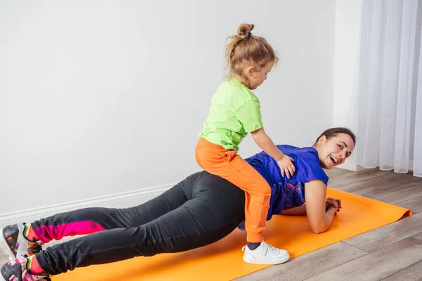 Actieve jongen leggen op zijn moeder terwijl ze staat in plank — Stockfoto