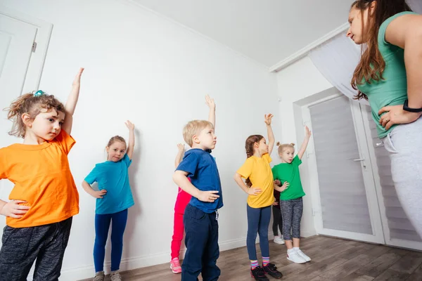 Actieve en gemotiveerde kinderen doen sport oefeningen op de kleuterschool — Stockfoto