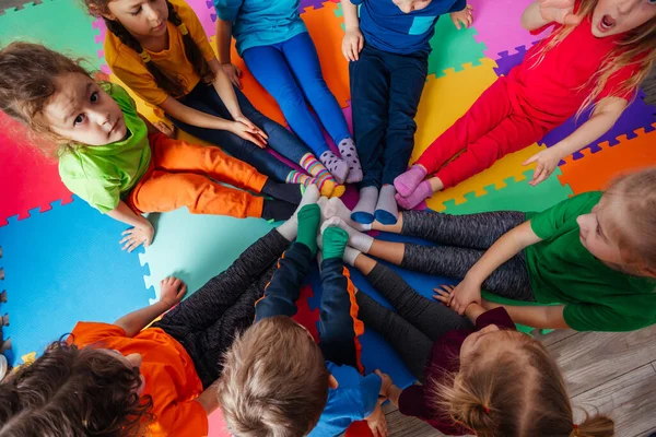Cercle de vue de dessus de jeunes enfants en vêtements colorés — Photo