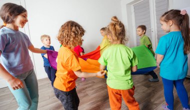 Dinamik ve takım renkli tenteli çocuklar için oyunlar inşa ediyor