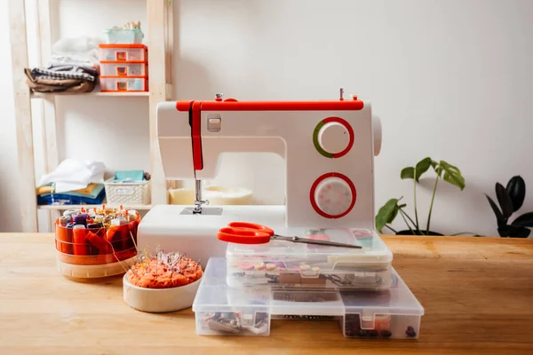 Современная швейная машина с различными нитями в коробке — стоковое фото