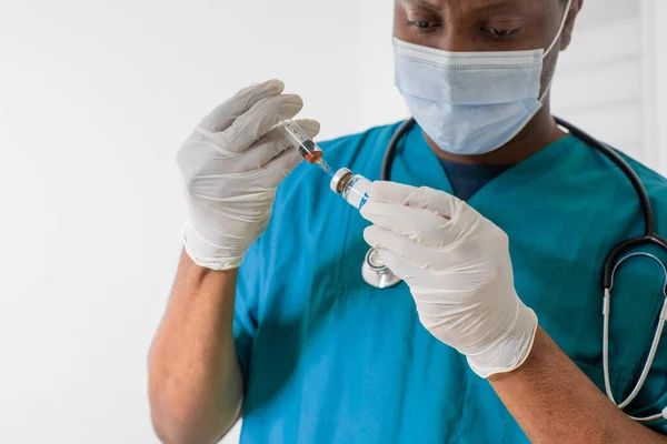 Médico con máscara médica que sostiene la jeringa con medicamentos — Foto de Stock