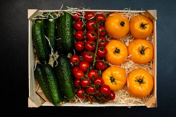 Lieferung von frischen Tomaten und Gurken in einer Holzkiste — Stockfoto
