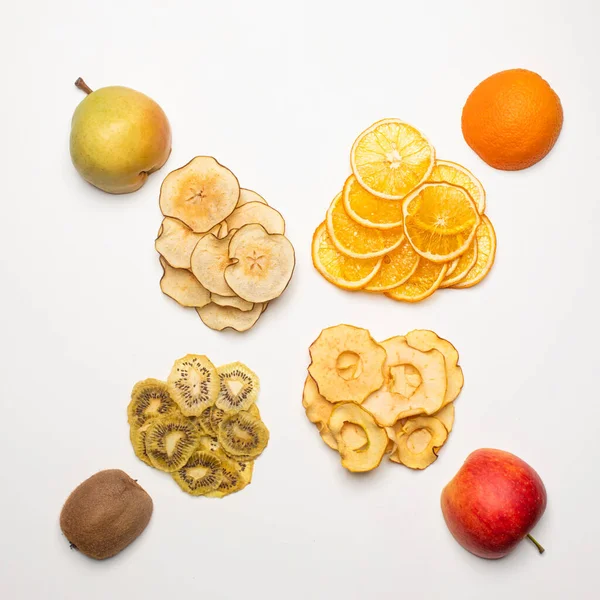 Les morceaux secs de différents fruits dans une rangée de fruits frais — Photo