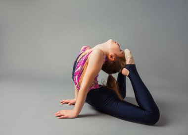 Soprts kostümlü küçük kız yüzük yapıyor.