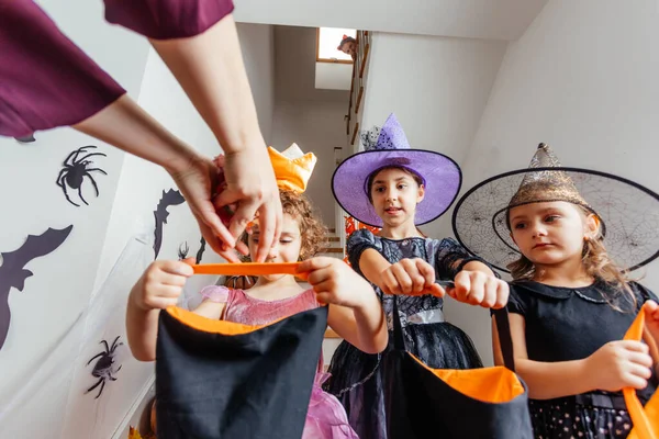 Meninas recebendo um monte de doces durante halloween truque ou tratamento — Fotografia de Stock