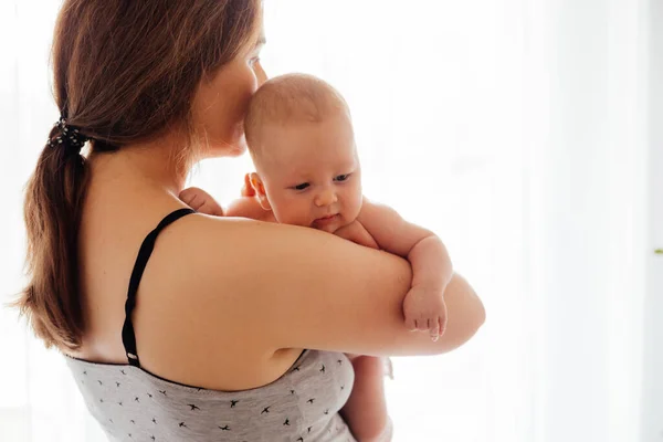 Moeder met naakt pasgeboren op verlichte witte achtergrond — Stockfoto