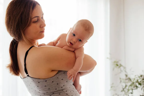 Madre con recién nacido desnudo sobre fondo blanco iluminado — Foto de Stock