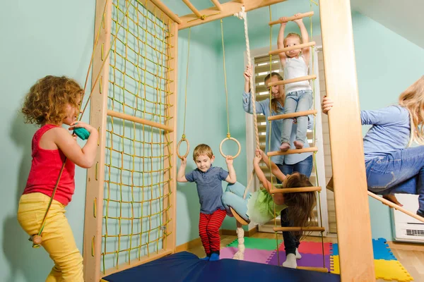 Занятие физкультурой в деревянном спортивном комплексе в детском саду — стоковое фото