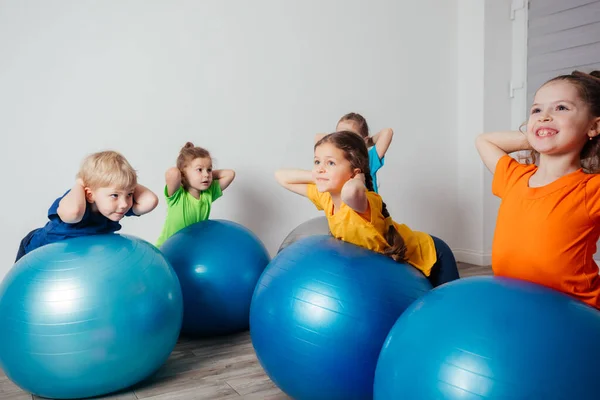 孩子们在大的健身球上做体育锻炼 — 图库照片