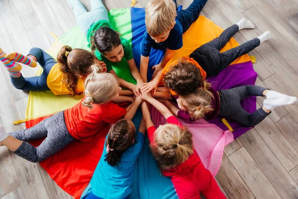 Happy kids laying on a floor in circle — Stock Photo, Image