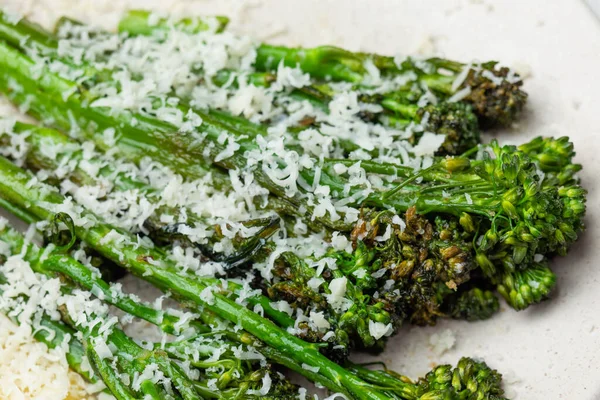 Broccolini fresco cocido con queso rallado y en el plato —  Fotos de Stock
