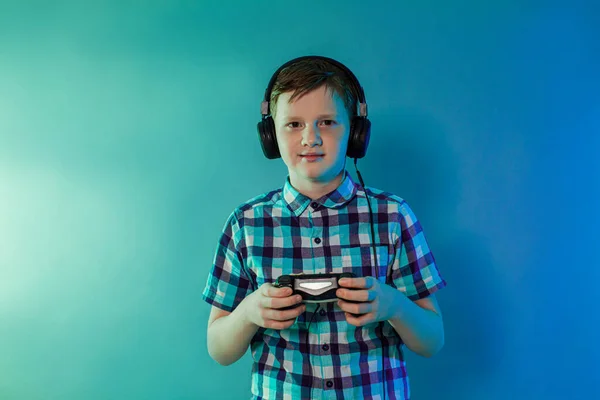 Teenager goy mit Kopfhörern auf dem Kopf mit einem Joystick spielen — Stockfoto