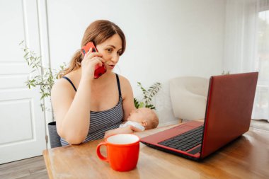 İş kadını uzaktan kumandayla yeni doğmuş bebeği tutuyor.