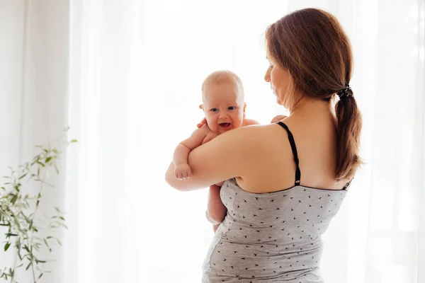 Мать с голым новорожденным на светлом белом фоне — стоковое фото