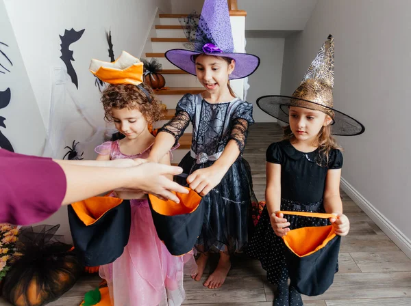 Dziewczyny otrzymujące kilka cukierków podczas halloween trick lub leczenia — Zdjęcie stockowe