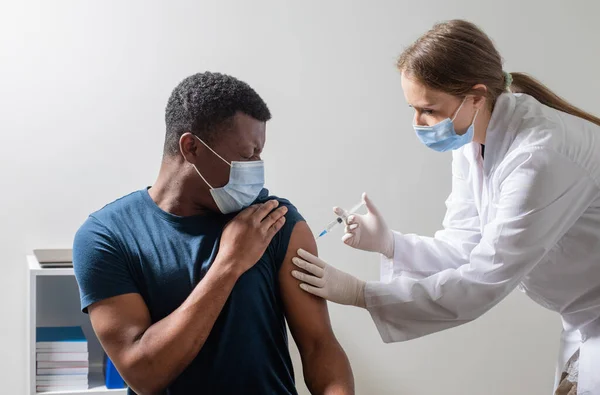 Vacunación durante pandemia covid, enfermera joven inyectable. — Foto de Stock