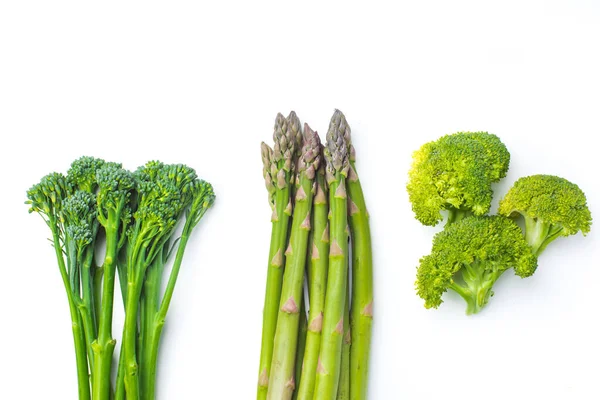 Raw broccolini i rad på vit bakgrund — Stockfoto