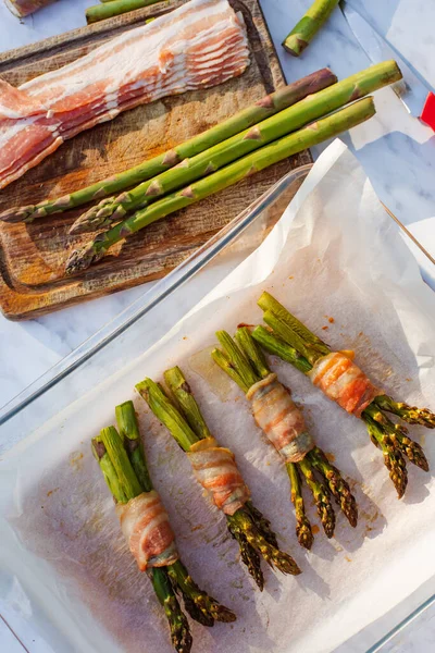 Espargos frescos embrulhados em bacon preparados para fritar — Fotografia de Stock