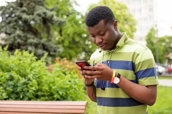 Retrato de un amigo afro americano de mensajería estudiantil en un smartphone — Foto de Stock