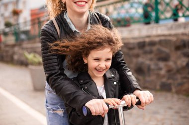 Anne ve kızı mobilete biniyor ve harika vakit geçiriyorlar.