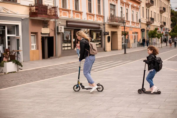 Стильна молода мама і дочка їздять скутери — стокове фото