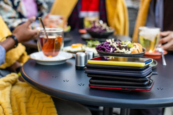 Stack av smartphones på svart bord på caféet — Stockfoto