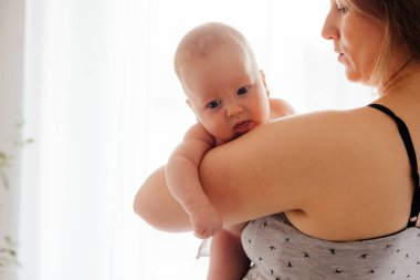 Işıklı beyaz arka planda çıplak yeni doğmuş bir anne.