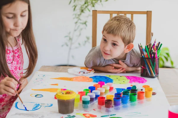 Дети с удовольствием рисуют красками на большой бумаге — стоковое фото