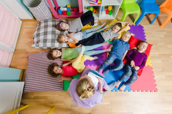 Actieve kinderen op zachte kussens en matten op de kleuterschool — Stockfoto