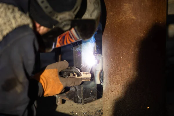 L'homme en uniforme soude un métal à l'usine — Photo