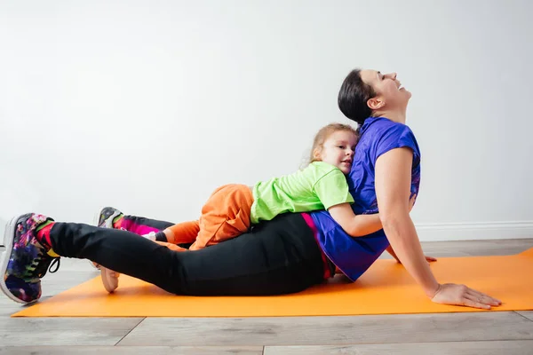 Actieve jongen leggen op zijn moeder terwijl ze staat in plank — Stockfoto