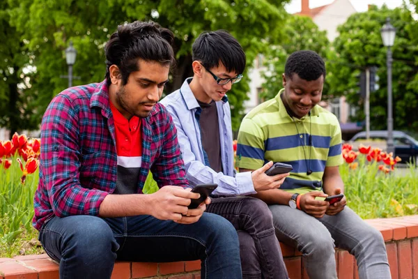 Vista de cerca de los hombres jóvenes mirando a los teléfonos inteligentes — Foto de Stock
