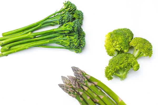 Raw broccolini i rad på vit bakgrund — Stockfoto